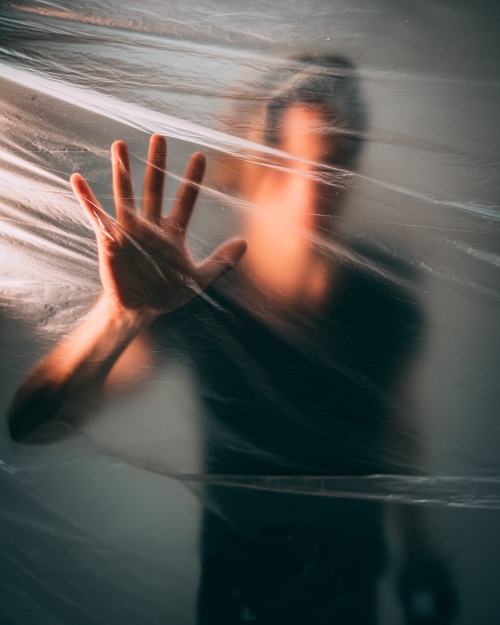 Man behind a plastic bag touching it with his palm Man behind a plastic bag touching it with his palm